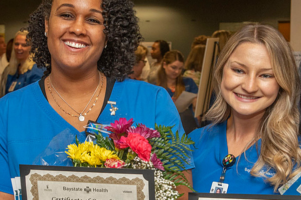 two smiling nursing residents at their graduation ceremony
