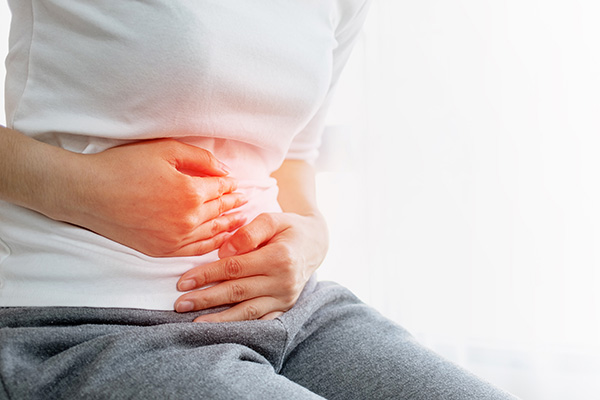 woman holding stomach in pain