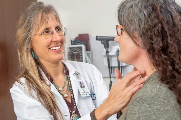 convenient care doctor grimes checking patient’s neck area using her fingers