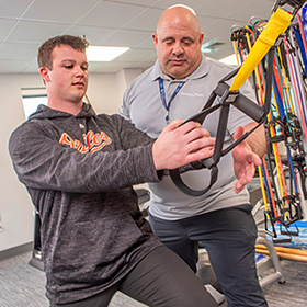 rehabilitation staff member assisting with a patients therapy