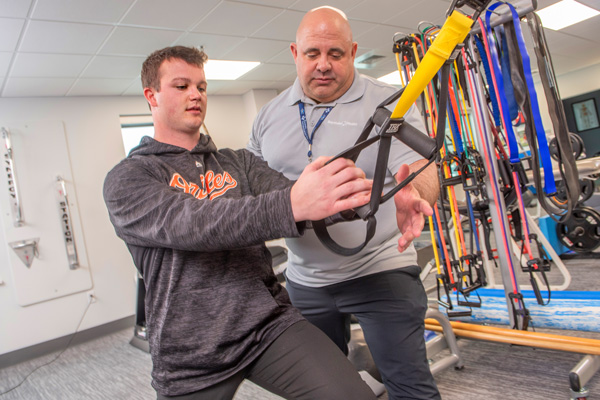 rehabilitation staff member assisting with a patients therapy