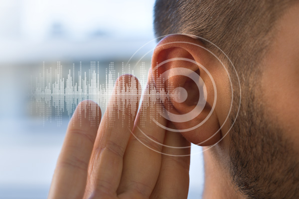 a man holding his hand up to his ear demonstrating hearing loss