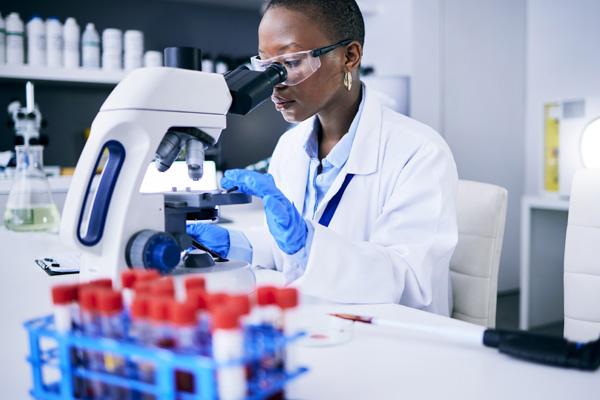 a doctor examining cells under a microscope