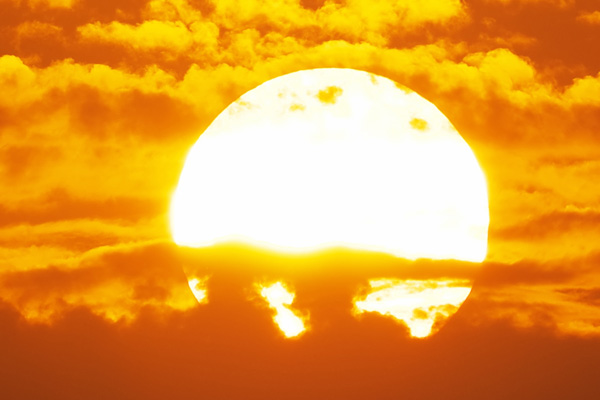 a bright sunset, turning all the clouds and sky around it shades of orange