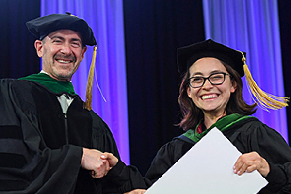 dr artenstein shaking the hand of a purch graduate at the graduation ceremony