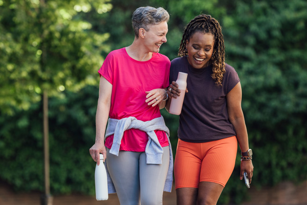 two menopause-aged women walking in nature