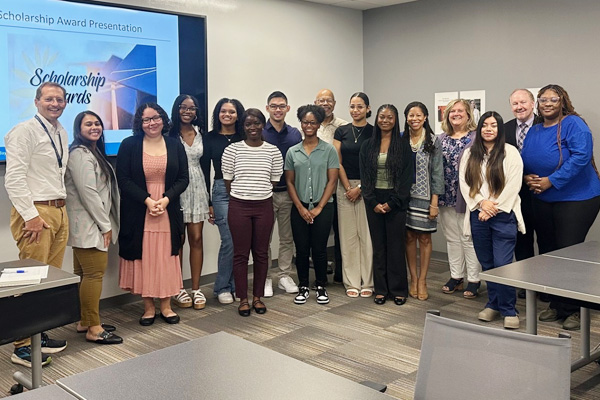 Baystate Springfield Educational Partnership scholarship winners pose together in front of a presentation board