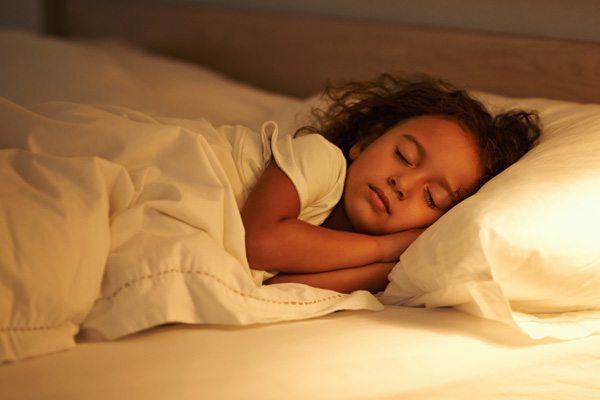 a little girl fast asleep in a bed