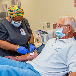 Bill getting blood taken from phlebotomist