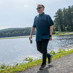 A man walking along a path next to water