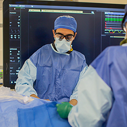 a doctor in surgical scrubs performing a TAVR procedure