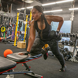 a Black woman lifting weights at the gym